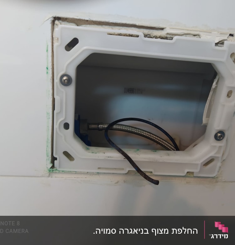 צינור מתכת וגומיות בתוך קיר פתוח